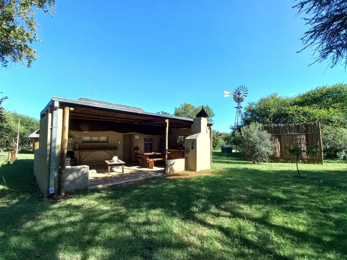 Archies Cottage exterior with private outdoor kitchen and braai area at Sun Acres Farm
